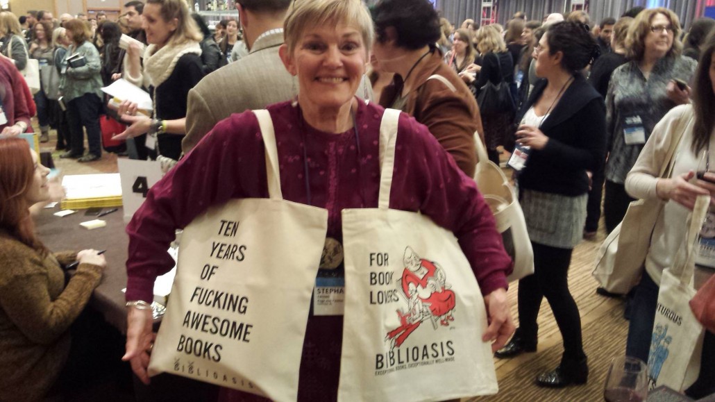 Stephanie of Page & Palette Bookstore in Fairhope, Alabama showing off her collection of Biblioasis totes.